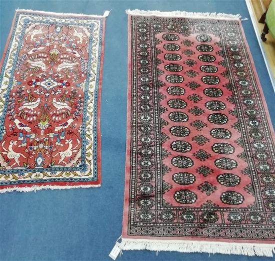 A Bokhara pink ground rug and a small Persian rug, woven with birds and animals (2) Larger 160cm x 90cm